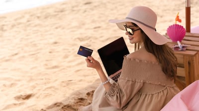 Mujer en playa con tarjeta