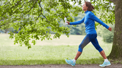 a woman in a blue shirt is running on a path