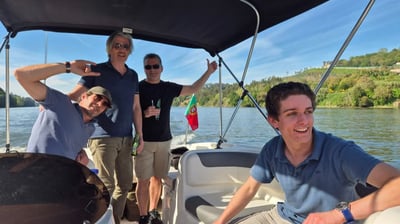 Smiling guests posing for a photo on the Endure speedboat on a quiet stretch of the Douro River
