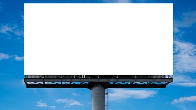 a billboard board with a blank white billboard on a cloudy day