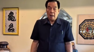a man in a blue shirt is holding a cake
