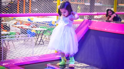 a little girl in a white dress and green socks