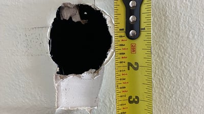 measuring a drywall hole for repair