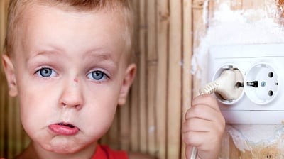 child near and unsafe wall outlet