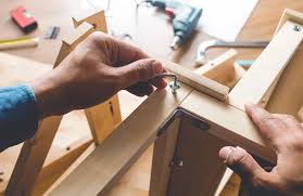 a hand holding a wrench assembling furniture