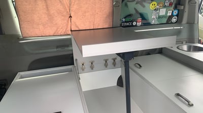 a explore africa camper van with a desk and a laptop on it
