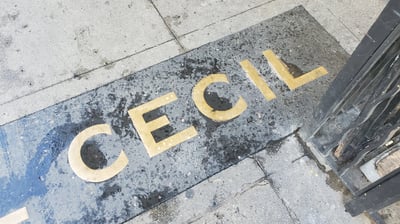 A brass sign in the sidewalk that says "Cecil"