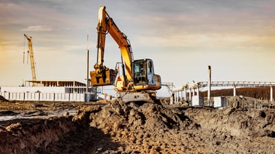 Bagger hebt Erde auf Baustelle aus, Aushubarbeiten für Fundament