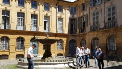 place avec une fontaine à Aix-en-Provence avec des personnes regardant l'architecture