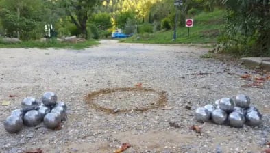 deux amas de boules de pétanques sur un terrain de pétanque