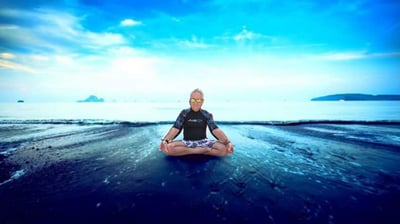 Philippe sitting in meditation on a beach