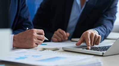 two men in suits and ties sitting at a table