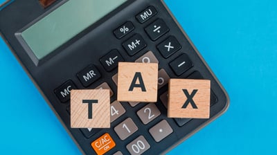 a calculator and a calculator with wooden blocks spelling tax