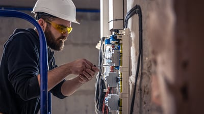 Tra technician installing HVAC ducts at a commercial project site