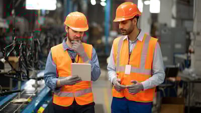 Tra technicians installing industrial equipment at a manufacturing plant