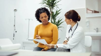 Médica entregando laudo de exame para cliente