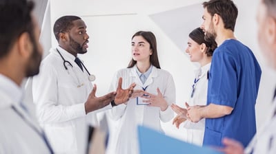Equipe de médicos e enfermeiros conversando com um paciente