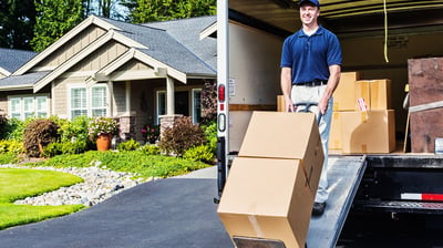 Man using a dolly to unload furniture and appliances from a box truck for delivery and assembly serv