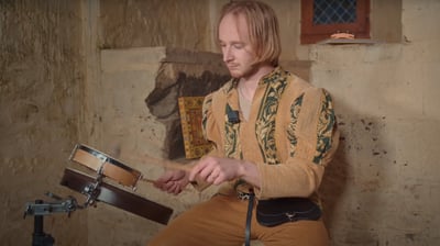 a man in a yellow shirt playing drums
