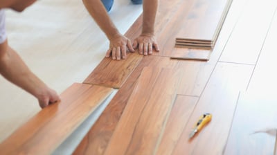 Professionals are installing click type floating laminate flooring.