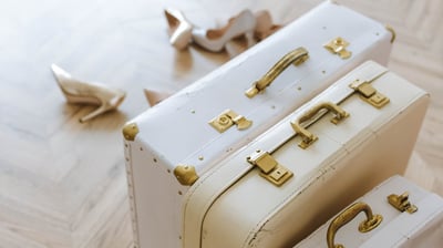 a pair of white suitcases sitting on a wooden floor