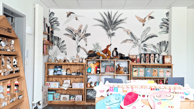 Transformation d'un magasin de jouets avec papier peint fleuri et meubles en bois