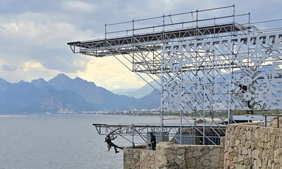 a man standing on a cliff face down into the ocean