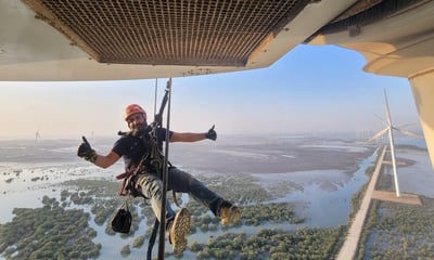a man is hanging from a helicopter while he is hanging from a rope