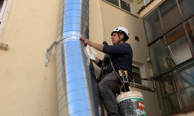 Trabajador arreglando tubería de ventilación