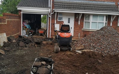 mini digger and wheel barrow outside a house in west brom