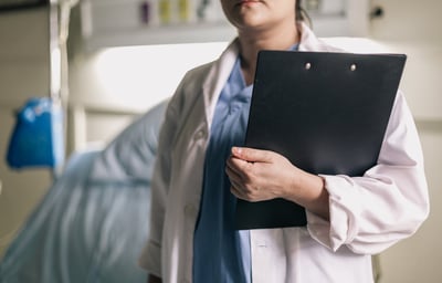 a woman in a hospital gown holding a clipboard