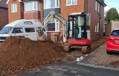 Micro digger digging footings in a Kings Norton driveway