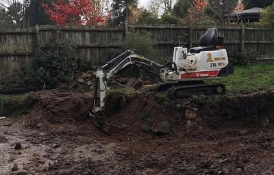 Mini digger excavating trench in Selly Oak garden