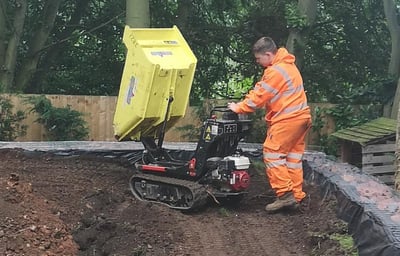 micro digger being pushed by a cmr grab and digger hire employee