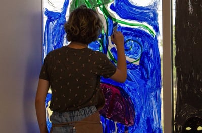 Young teen painting jellyfish on the window of our studio.