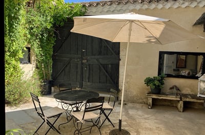 a patio table with chairs and umbrellas