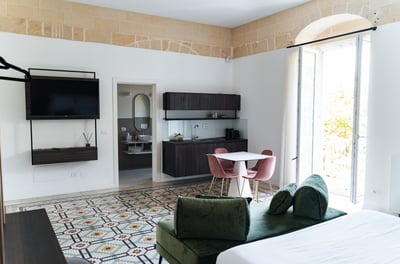 a bedroom with a bed, couch, and television