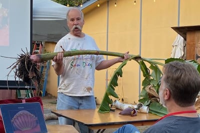 Jon Verdick holds a banana tree up for the audience