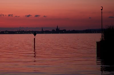 Bottighofen am Bodensee – Abendrot mit Silhouette von Konstanz am gegenüberliegenden Ufer