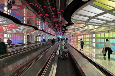 a group of people walking down a long escalator