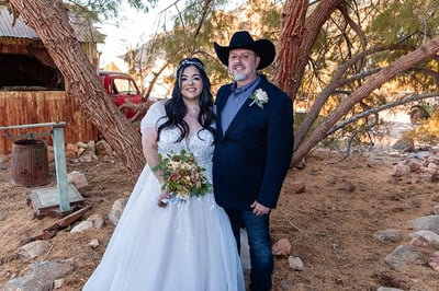 a man and woman in cowboy hats and wedding gowns