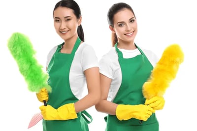 two women in green aprons holding cleaning supplies
