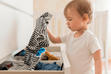 image d'enfant choisissant seul ses vêtements dans un tiroir