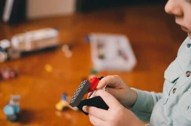 image des mains d'un enfant avec un jeu de construction