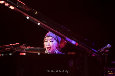 Aki Tekase spielt auf der Bühne ein Klavier.
