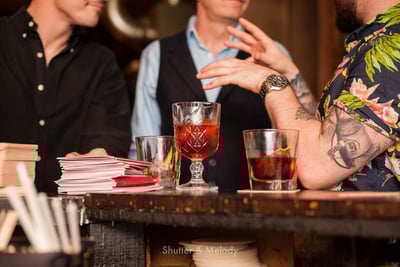 Barbesucher unterhalten sich bei einem Glas Negronis.