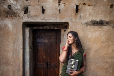 a woman in a saree posing infront of the wall