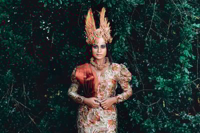 a woman in a dress and a hat with feathers on it