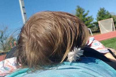 a woman and child laying on a blanket in the grass