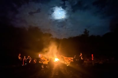 a group of people sitting around a campfire